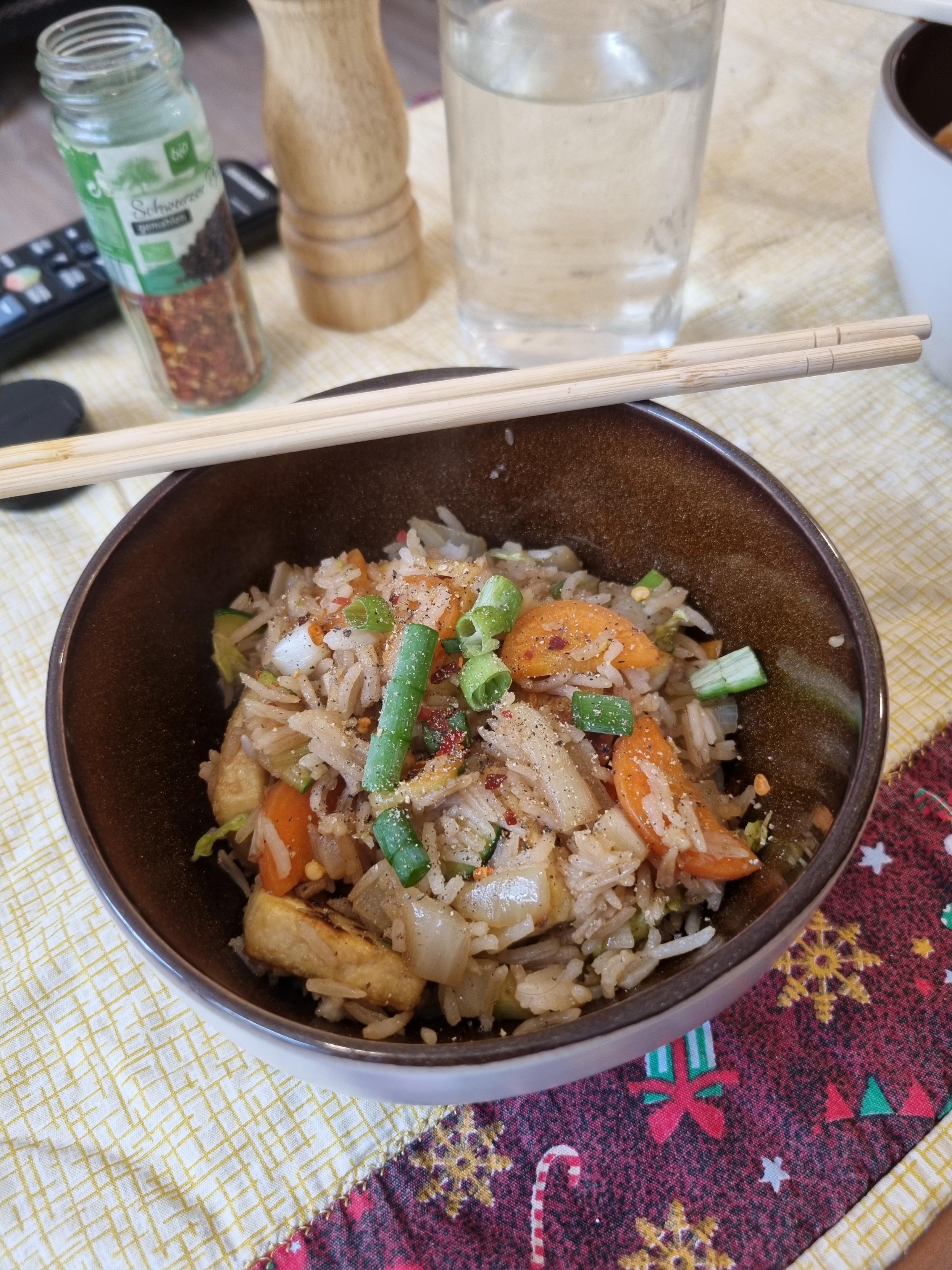 Prato de arroz frito com tofu, cenoura,  cebpla e cebolinha.
