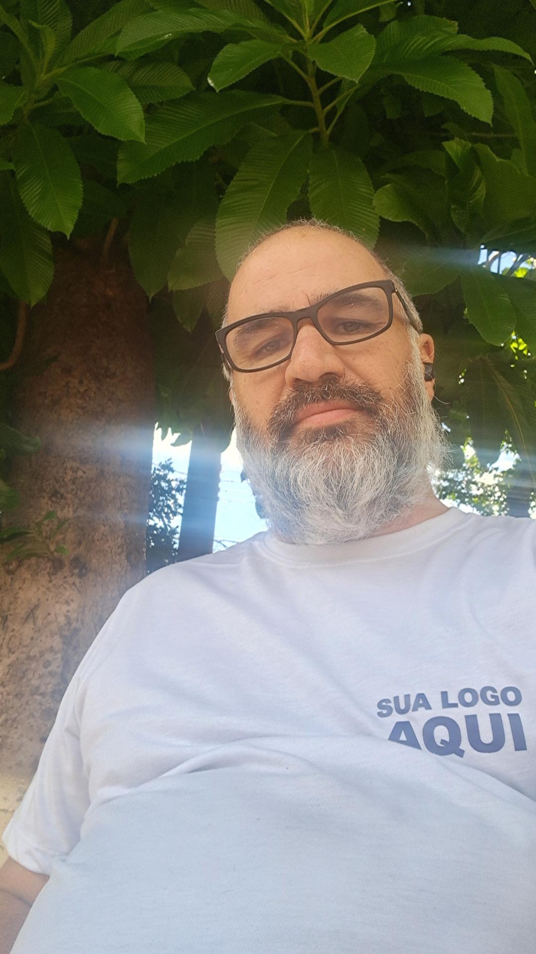 Sentado num banco à sombra de uma árvore